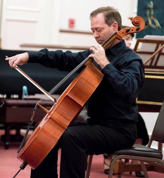 Thomas Shoebotham playing a cello.