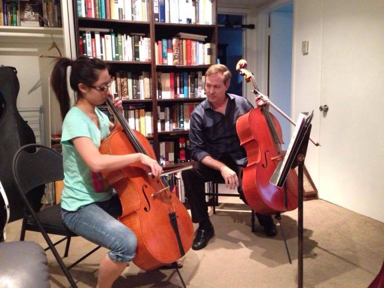 Thomas teaching cello to a student